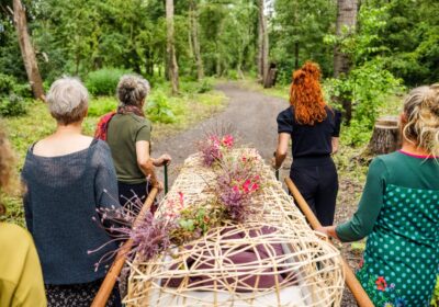 Nabestaanden begeleiden overledene naar laatste rustplaats.